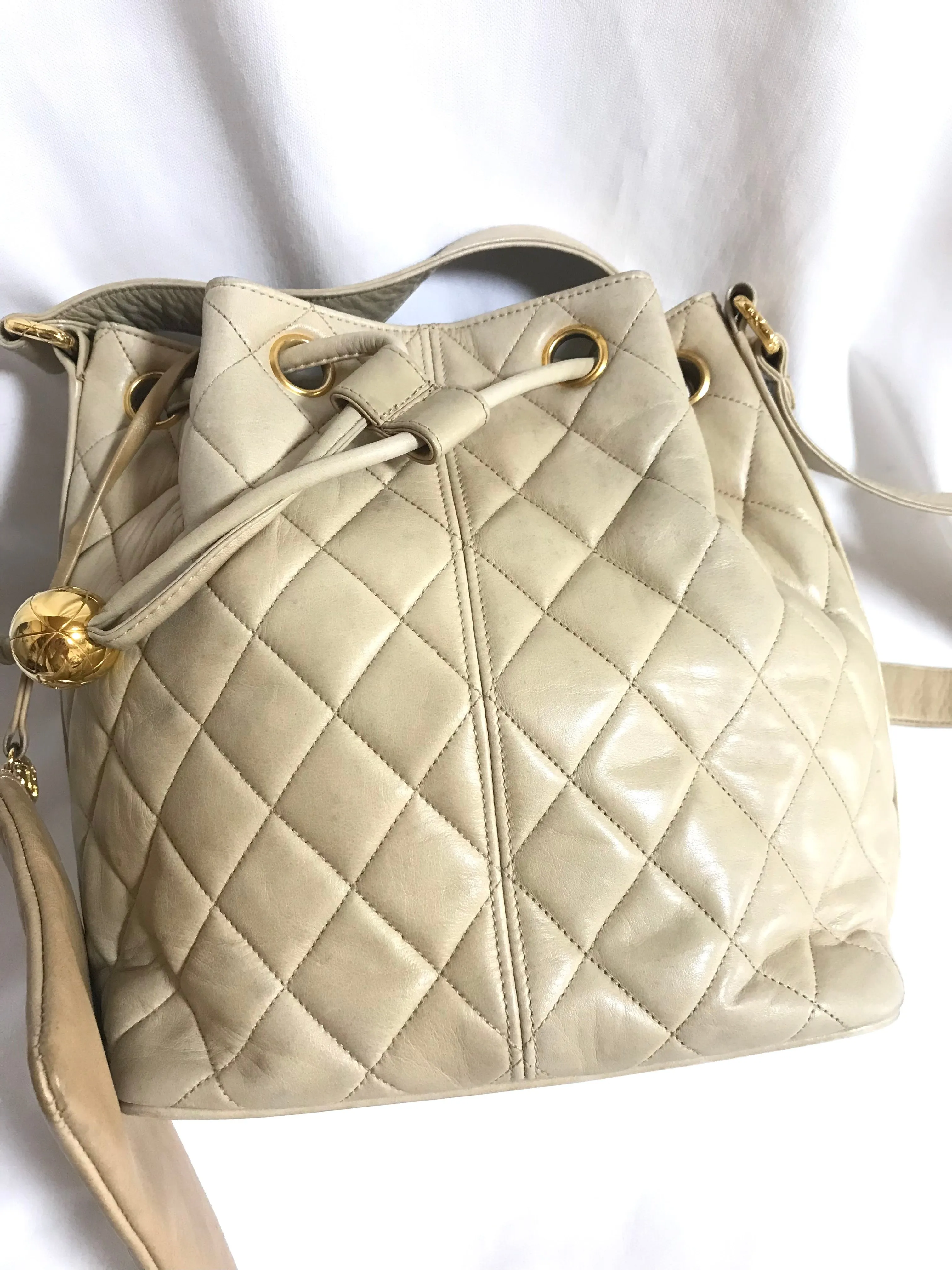 Vintage CHANEL beige quilted lamb leather hobo bucket shoulder bag with drawstrings and golden CC mark ball. 050320r3