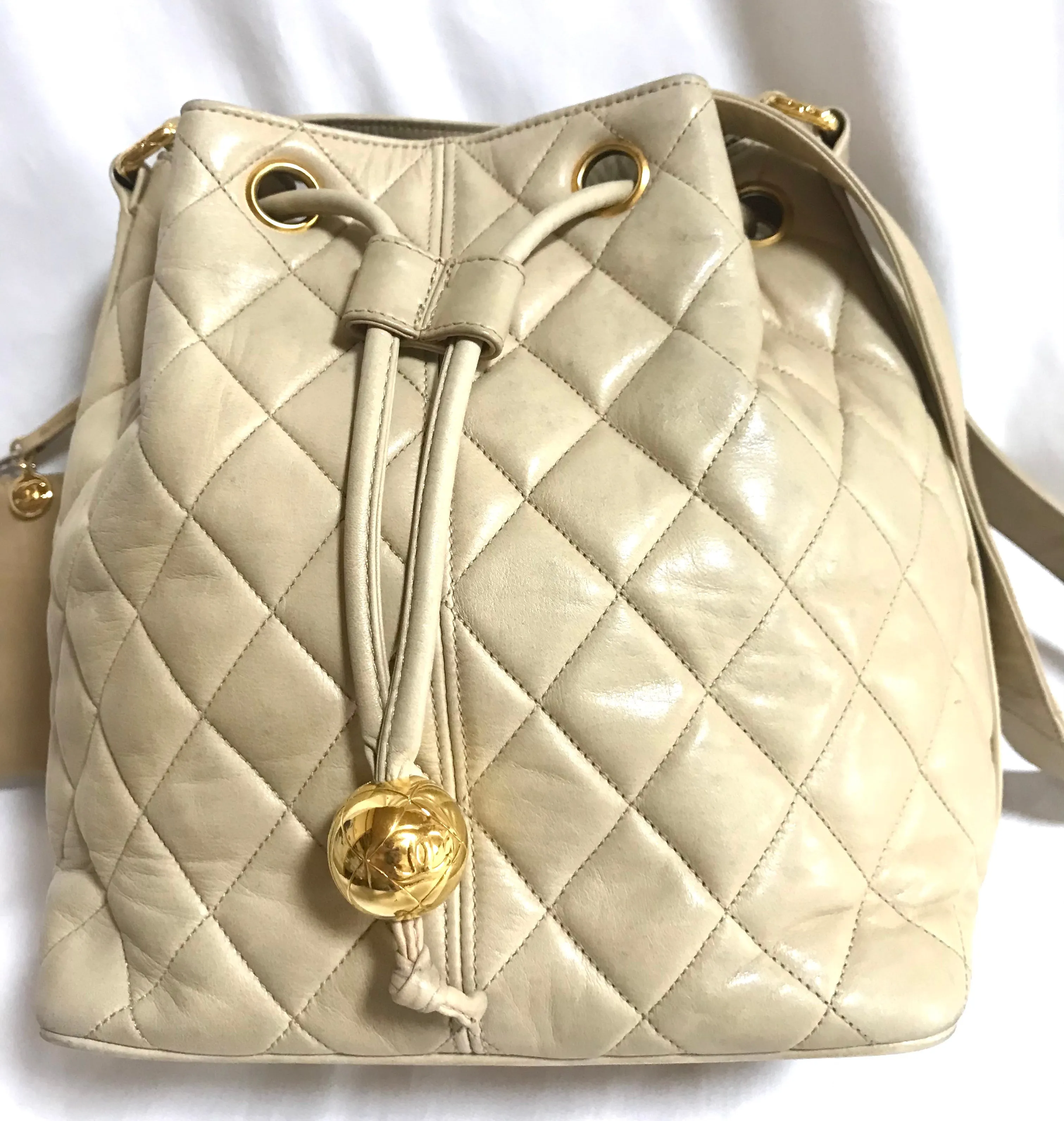 Vintage CHANEL beige quilted lamb leather hobo bucket shoulder bag with drawstrings and golden CC mark ball. 050320r3