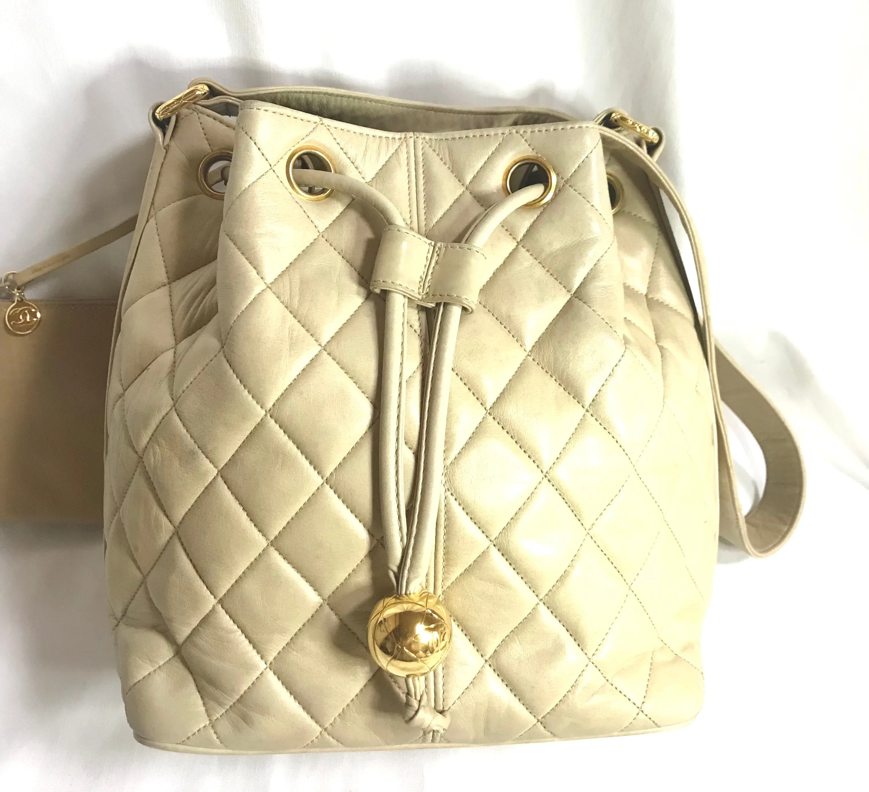 Vintage CHANEL beige quilted lamb leather hobo bucket shoulder bag with drawstrings and golden CC mark ball. 050320r3
