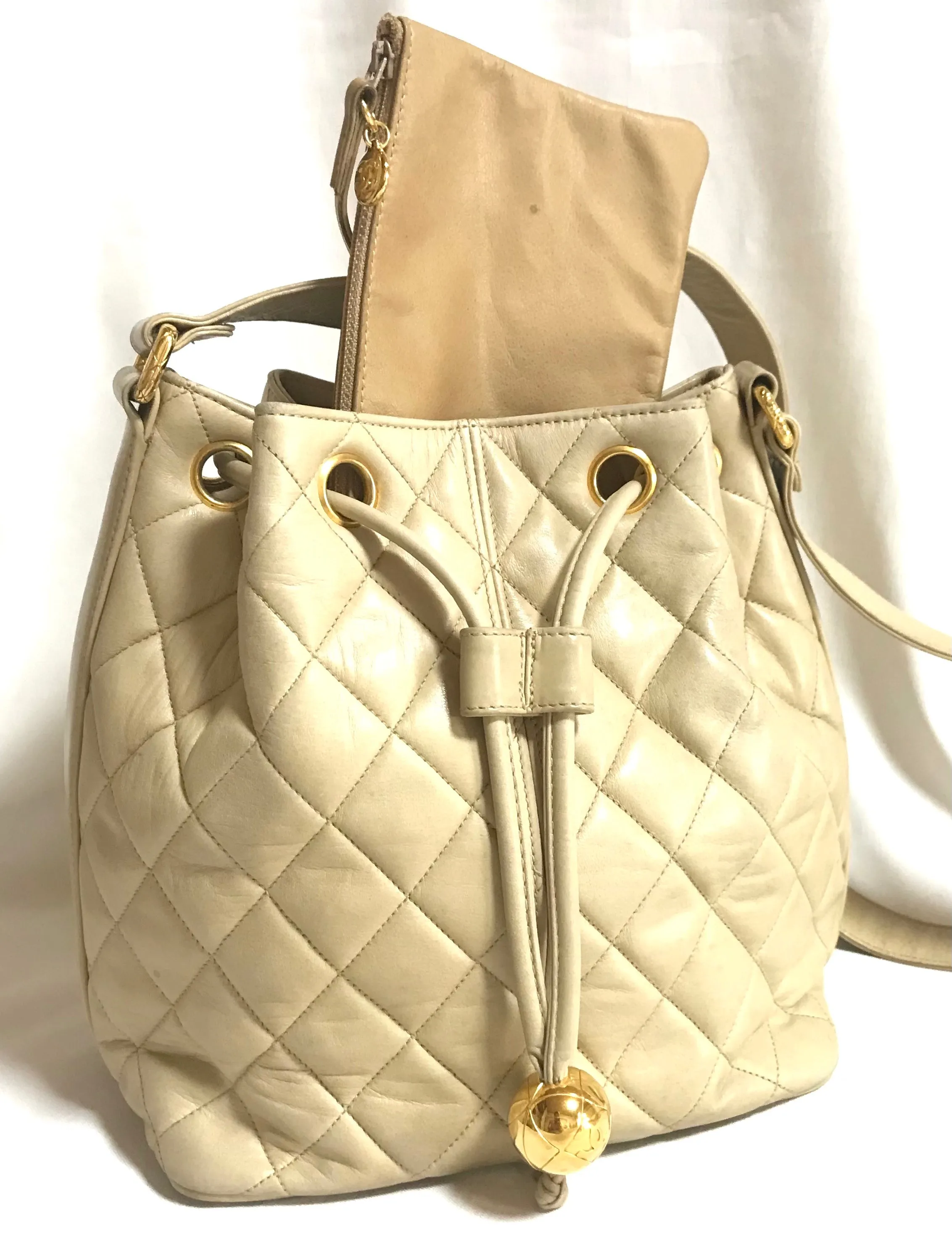 Vintage CHANEL beige quilted lamb leather hobo bucket shoulder bag with drawstrings and golden CC mark ball. 050320r3