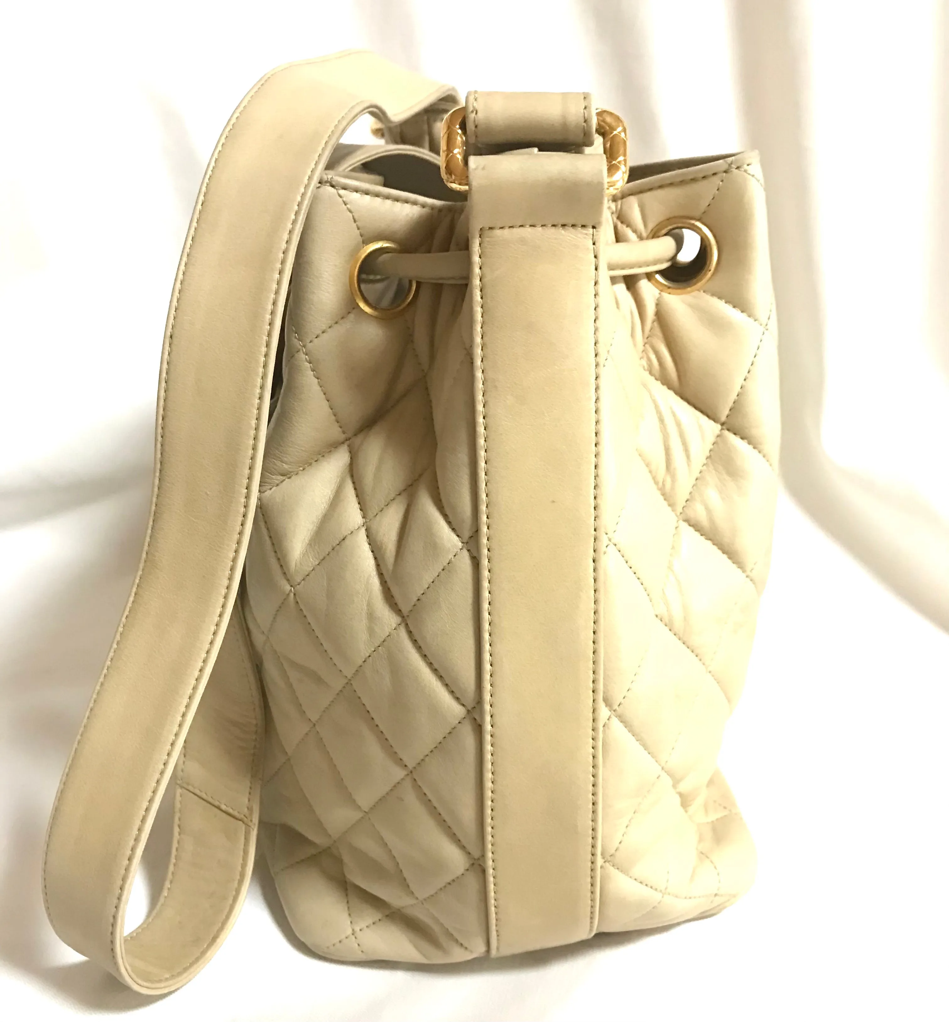 Vintage CHANEL beige quilted lamb leather hobo bucket shoulder bag with drawstrings and golden CC mark ball. 050320r3