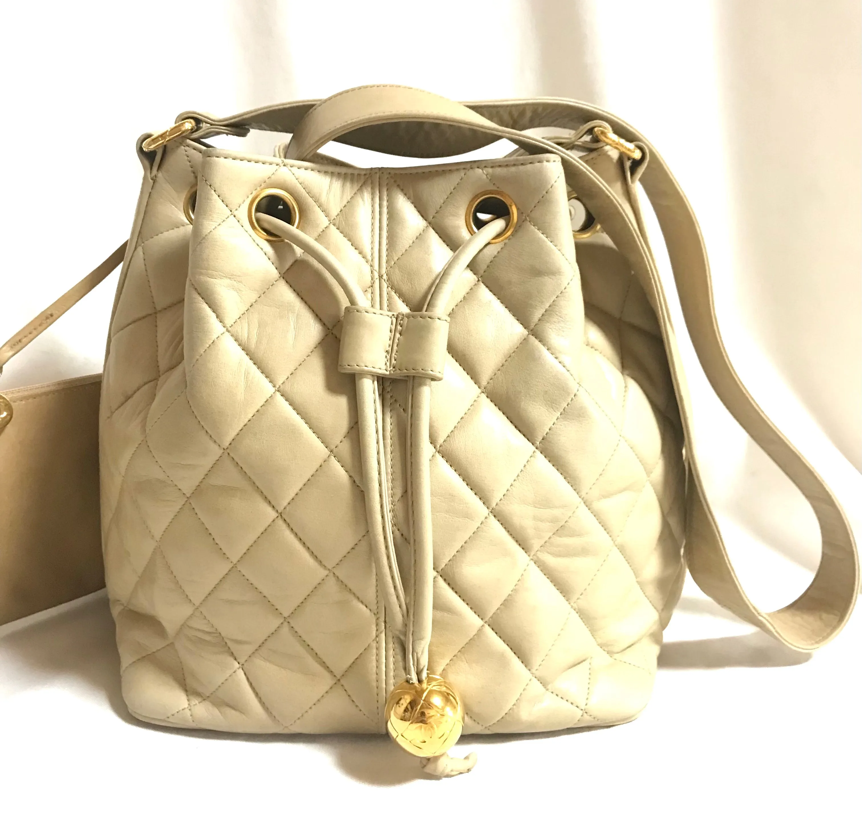 Vintage CHANEL beige quilted lamb leather hobo bucket shoulder bag with drawstrings and golden CC mark ball. 050320r3